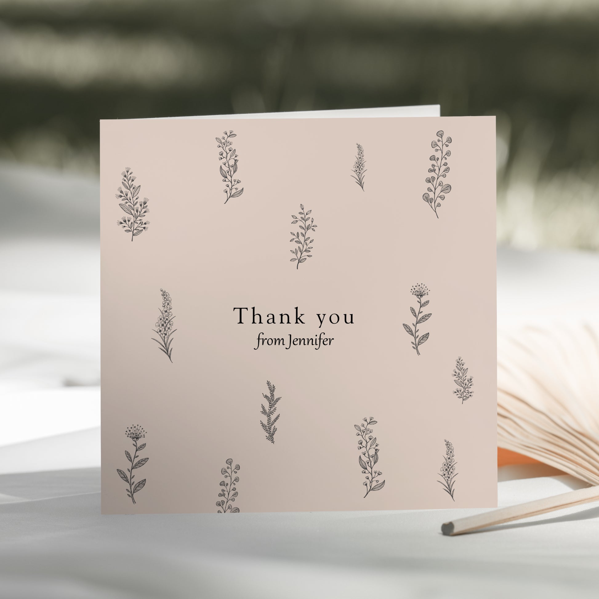 a thank you card sitting next to an open book