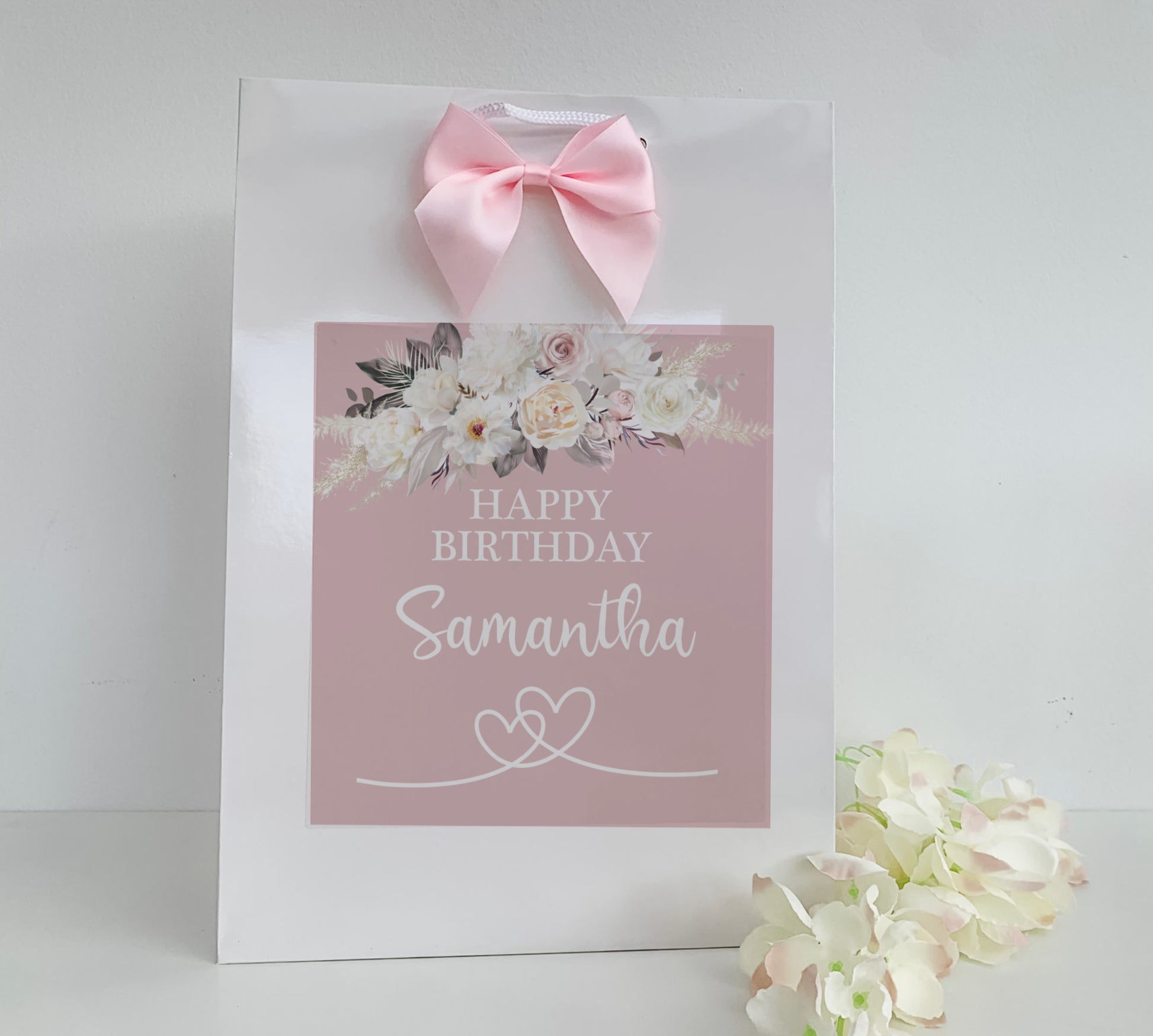 a pink birthday card with a pink bow on it