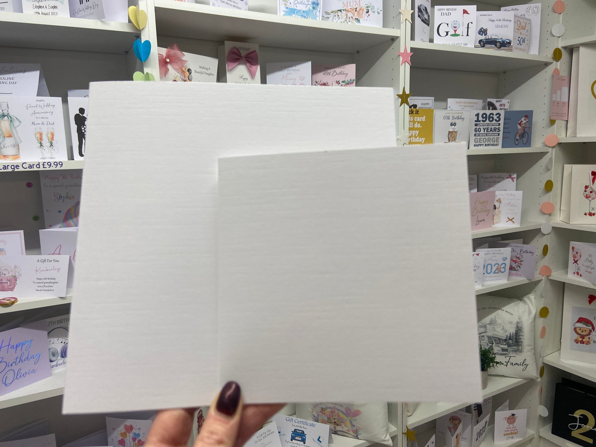 a person holding a piece of paper in front of a wall of cards