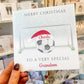 a person holding up a christmas card with a soccer ball on it