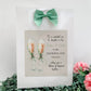 a picture of two champagne flutes with a green bow