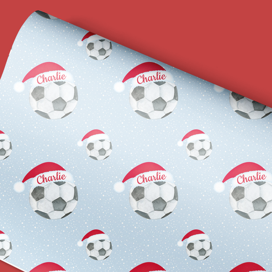 a red and white christmas wrapping paper with soccer balls