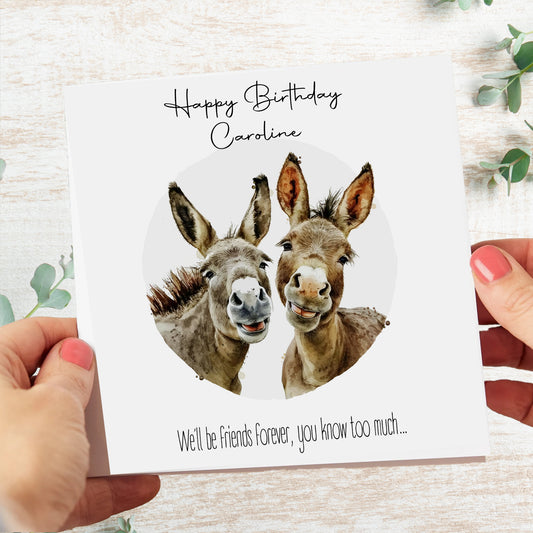 a person holding a card with two donkeys on it