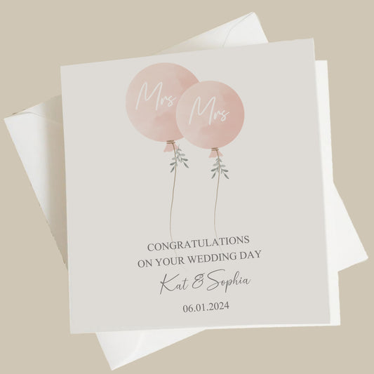 a couple of pink balloons on top of a card