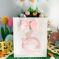 a greeting card with a pink bow on top of it