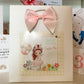 a card with a pink bow on top of it