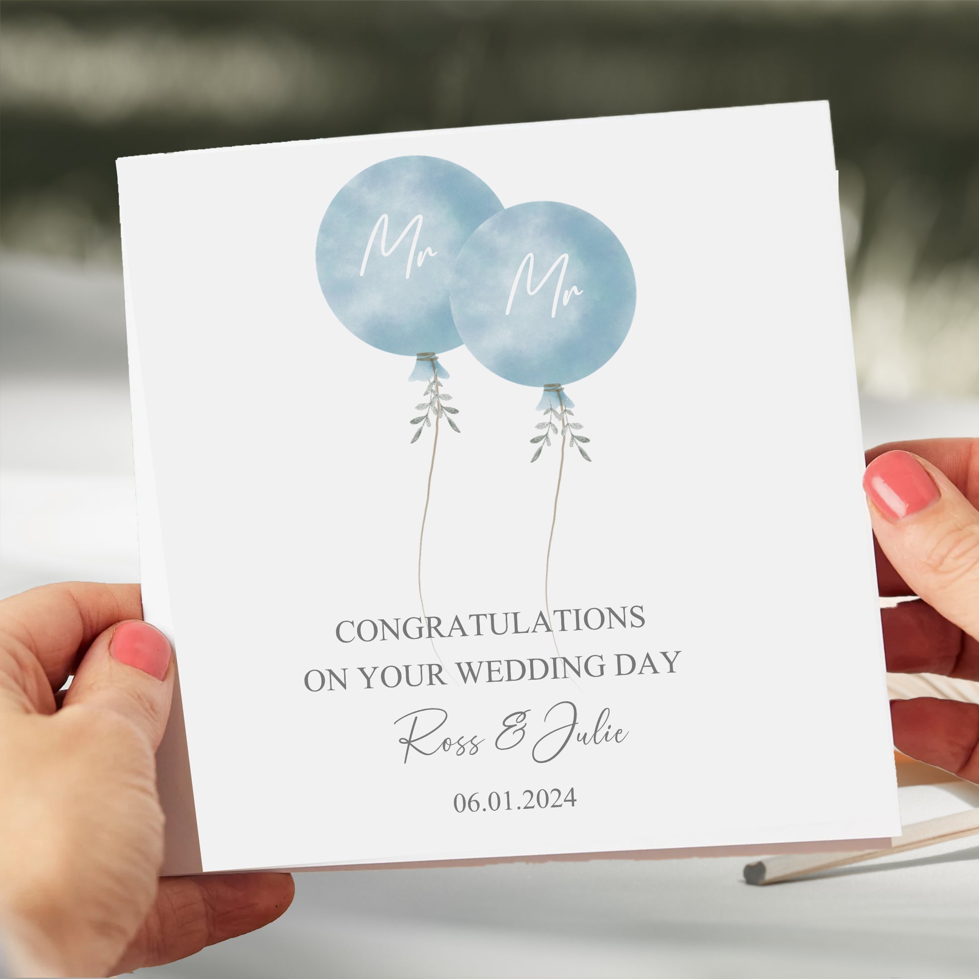 a person holding a card with balloons on it