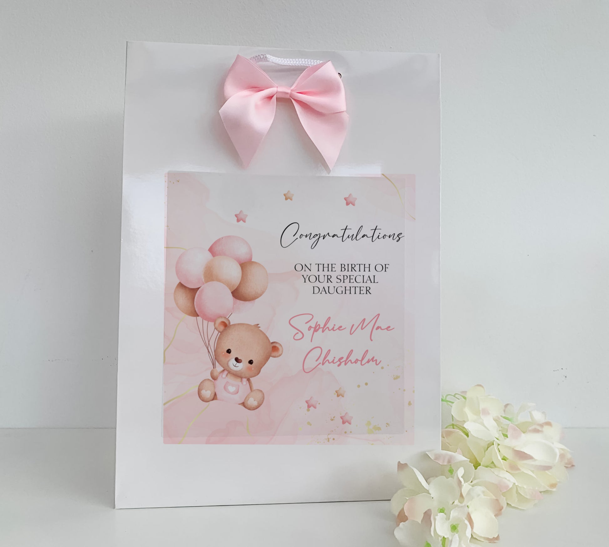 a greeting card with a teddy bear holding balloons