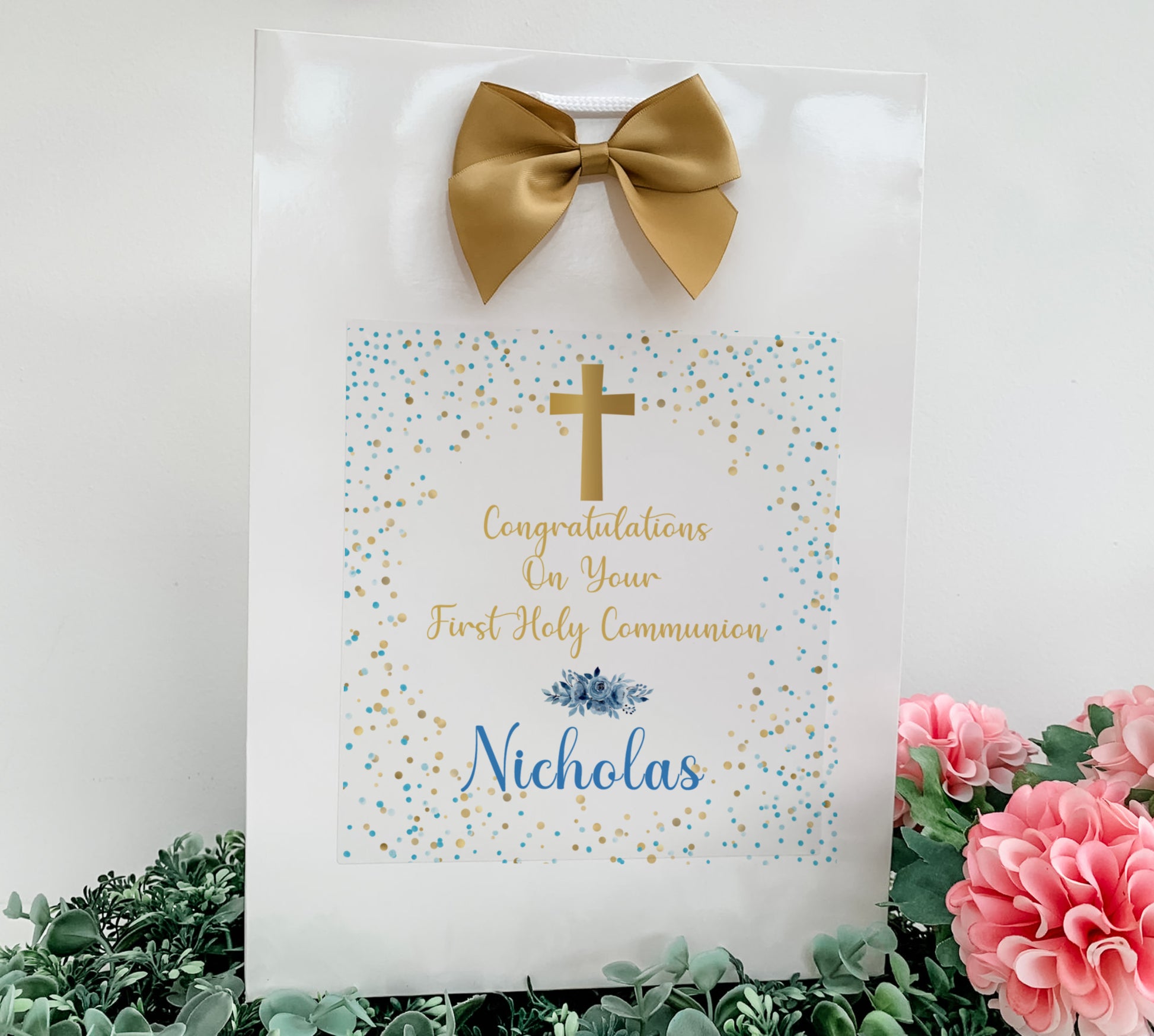 a white bag with a gold bow on top of it