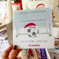 a person holding up a christmas card with a soccer ball on it