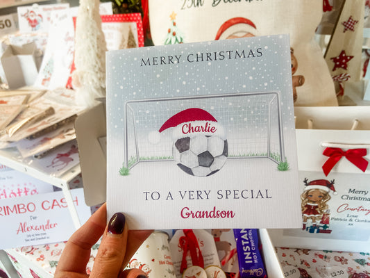 a person holding up a christmas card with a soccer ball on it